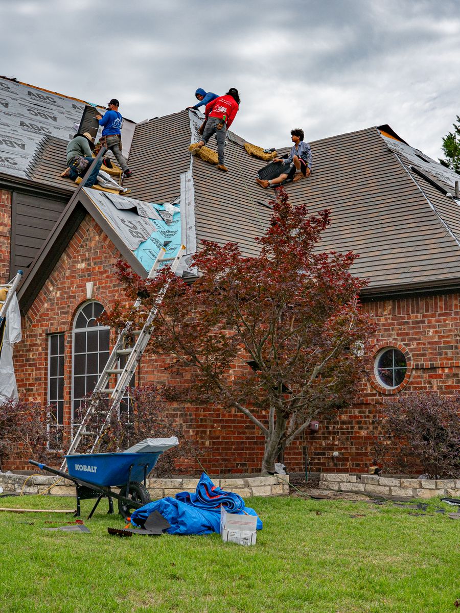 A crew working on a home exterior and roof