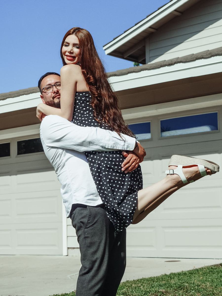 A couple smiling outside their new home