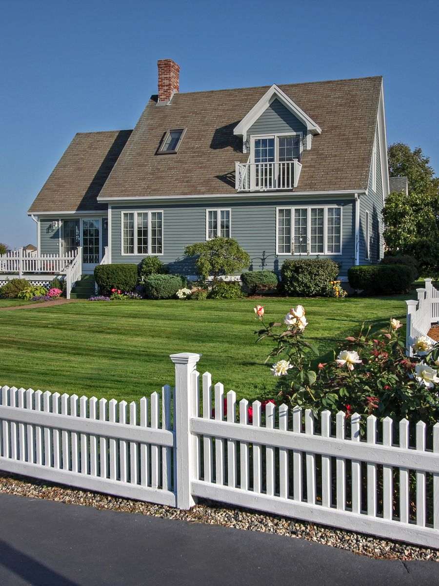 A bright suburban home with a white picket fence